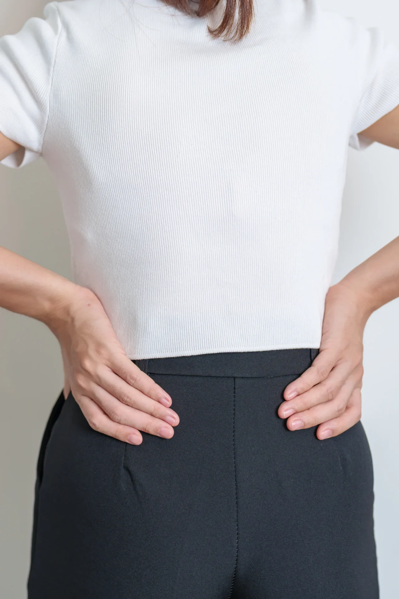 adult woman holding lower back in discomfort indoo 2026 03 19 23 41 47 utc