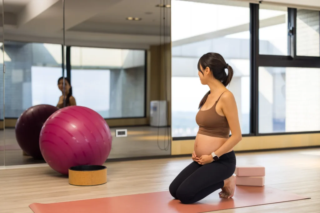 pregnant woman practicing yoga in a sunlit studio