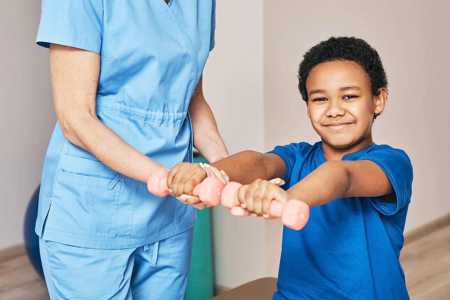 smiling boy working with physical therapist